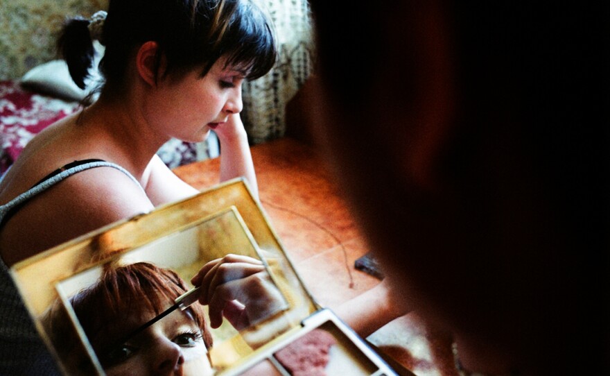 Two Moldovan women apply makeup before going out with friends.