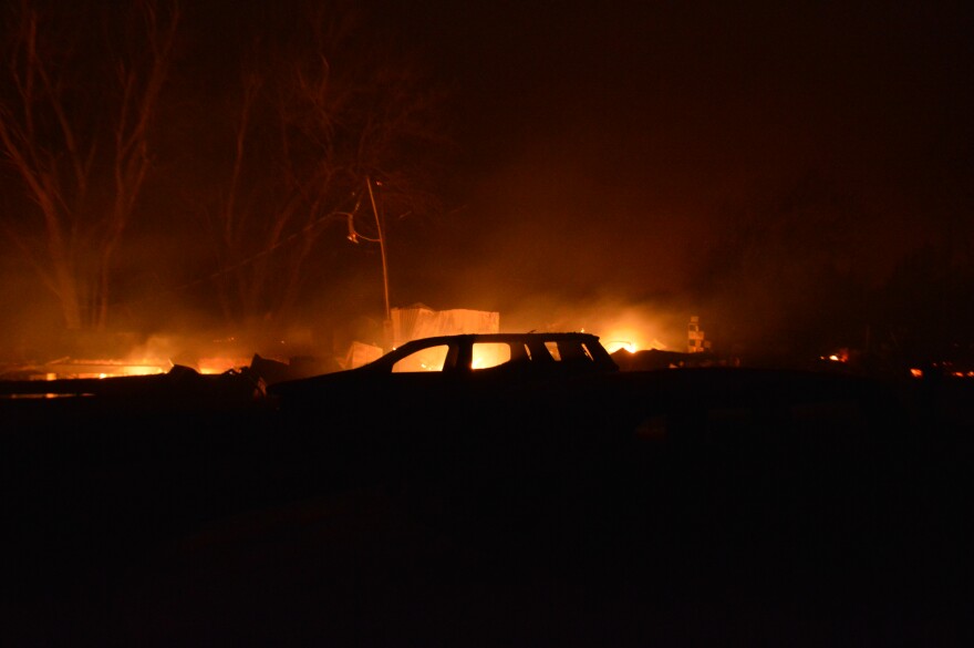 The scorched remains of a car sit on a smoldering lot Friday, March 14, in Pawnee County.