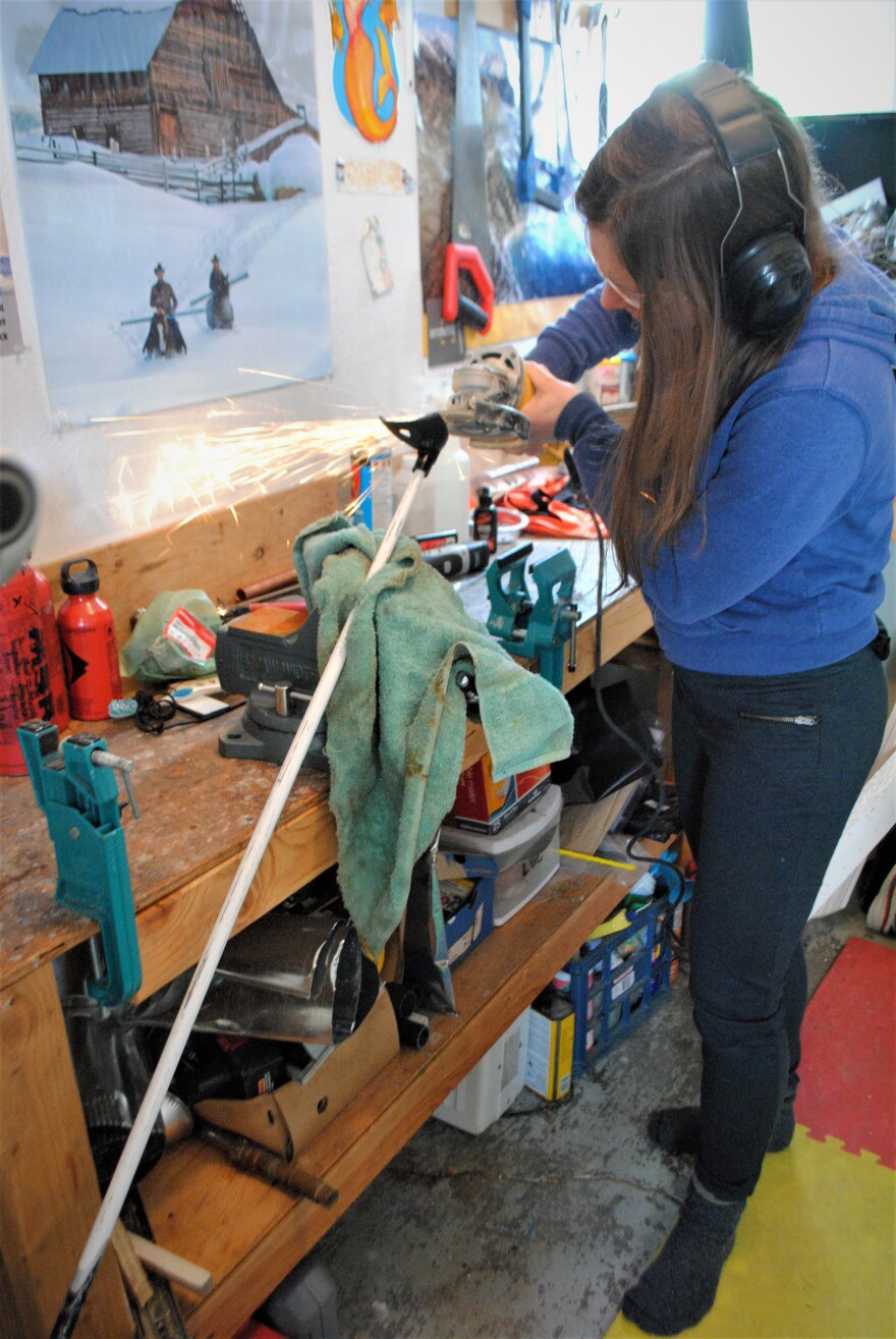 Sarah Histand grinds down the tips of her ski poles so the sharp tips can grab onto glare ice. (Emily Russell/Alaska Public Media)