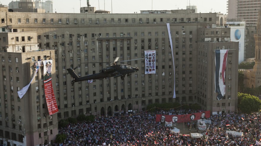 An Egyptian Apache helicopter flies over a crowd of pro-military demonstrators at Tahrir Square in Cairo on July 26. U.S. firms supply military hardware to the military, including the Apache helicopters.