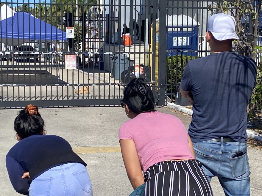 A Cuban family from Tampa peers through the gate at the U.S. Custom and Border Protection facility in Marathon in the Florida Keys, trying to glimpse a relative who just arrived by sea from Cuba.