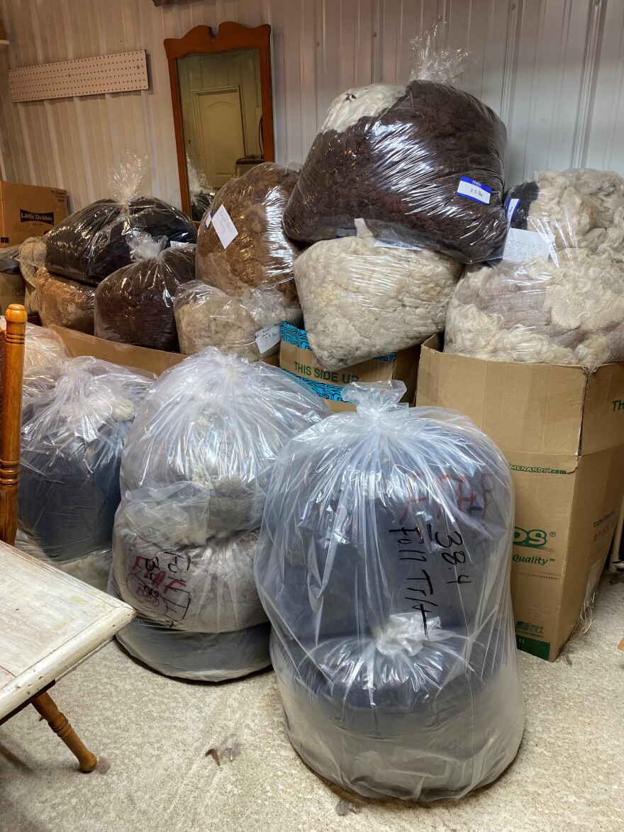Clear plastic bags and cardboard boxes of fiber are stacked up against the wall of a room at America's Natural Fiberworks mini-mill.