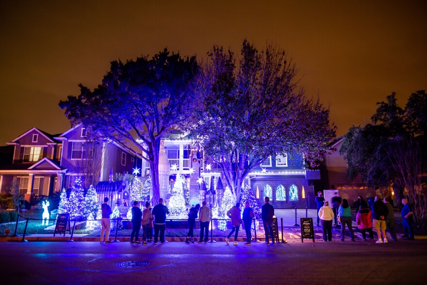 People look at Joel Pace's home in Austin's Circle C neighborhood on Dec. 13. Each year, Pace creates an elaborate Harry Potter-themed display in his yard for the holidays. 