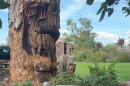 A deer with antlers is carved into a tree stump