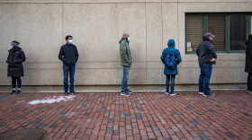 People stand in line and wait to be tested outside of the Tufts coronavirus testing center on Tremont Street. (Jesse Costa/WBUR)
