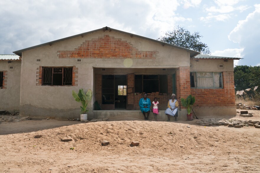 Florence Machinga with her daughter Hazel and mother Rosemary at the home they are slowly rebuilding after it was destroyed in 2008.