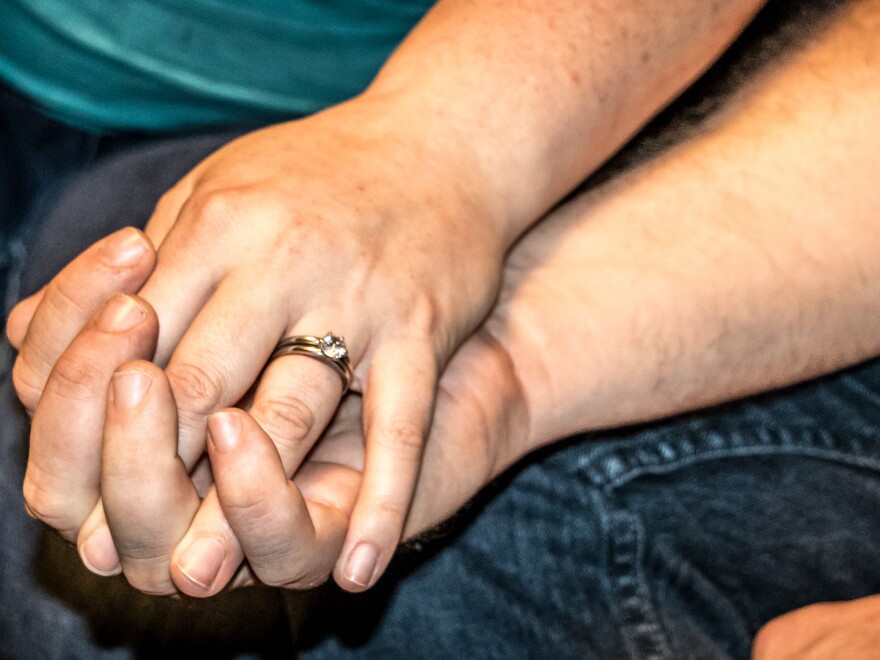 Greg and Judy hold hands at their home in Guthrie, Okla. The couple can't find integrated mental health and opioid addiction treatment for Greg in their area.