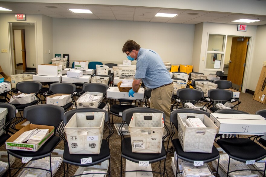 Election official Jim Fortner places a crate of sorted absentee ballots with others from the same ward at the Madison, Wis., City-County Building on Aug. 5, 2020. Delays and failure to deliver absentee ballots in Wisconsin and other key swing states have sparked concerns about how well the November presidential election will be managed during the pandemic.