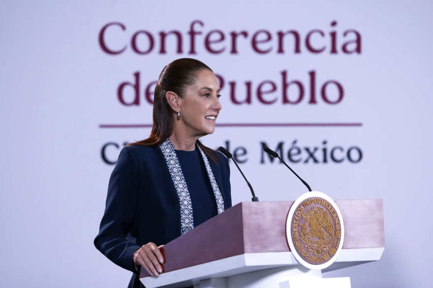 Mexican President Claudia Sheinbaum addresses the media standing behind a podium