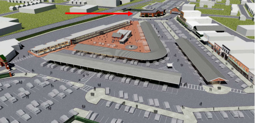 A red arrow points to where a new storefront building – possibly with upper floors of apartments –  could be built at the North Union Street entrance to the Rochester Public Market. The areal rendering looks west over the market with North Union Street in the background.