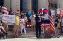 Anthony Sabatini at the foot of the steps of the courthouse, behind him on the steps are people with signs protesting the mask mandate.