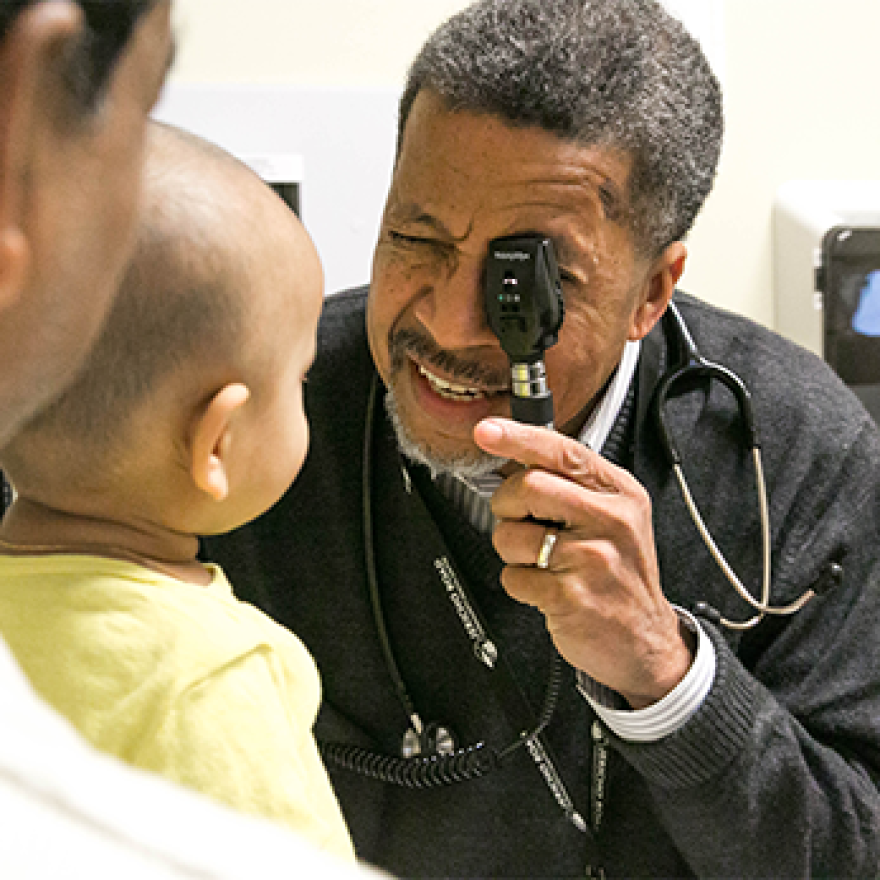 A doctor examines the eyes of a toddler