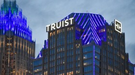 The Truist logo lights up atop Truist Tower in uptown Charlotte at dusk on Oct. 5, 2023.