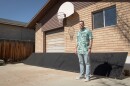 Alex Giesey stands in front of his backyard solar panels in West Jordan, March 20, 2026
