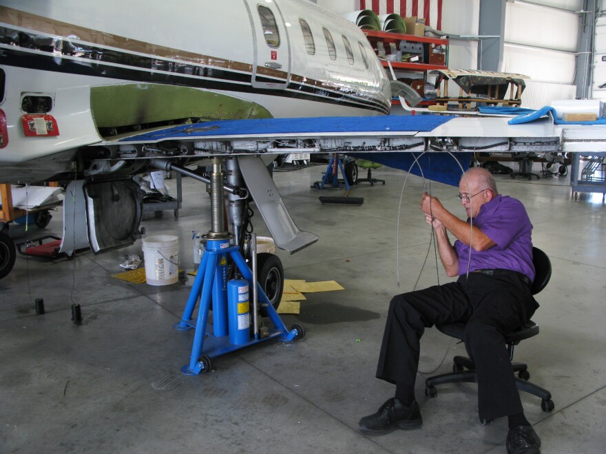 Mike Catherwood works on a Lear jet in a hangar in Springfield. The retired Air Force mechanic says his company, Spectra Jet, has so much work it needs more space.