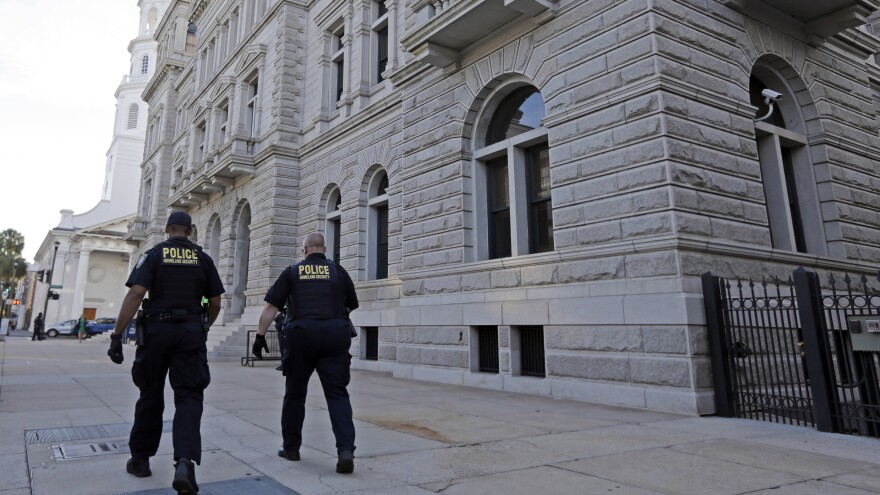 Homeland Security officers walk outside the federal courthouse in Charleston, S.C. Jury selection in the case will resume Monday.