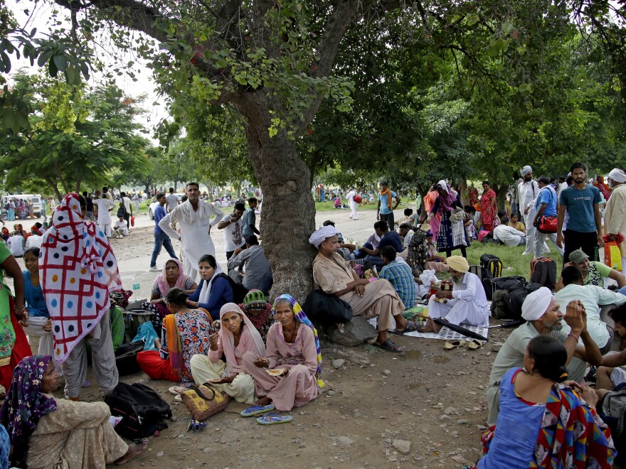 Supporters of the Dera Sacha Sauda sect wait near an Indian court in Panchkula last Thursday, a day before their spiritual leader Gurmeet Ram Rahim Singh was convicted of rape. Many of Singh's supporters are low-caste or Dalits, previously known as "untouchables," who turned to his ashram for basics such as food and medicine.