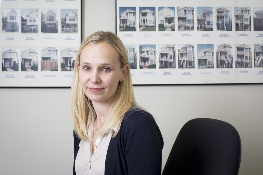 Kristen Komara, vice president of financial wellness at the Resurrection Project, pictured at the Resurrection Project in Pilsen on Nov. 6, 2017, in Chicago. The houses pictured behind are of the first 140 homes built by the organization in the '90s that it then helped community members purchase. (Michelle Kanaar for Here & Now)