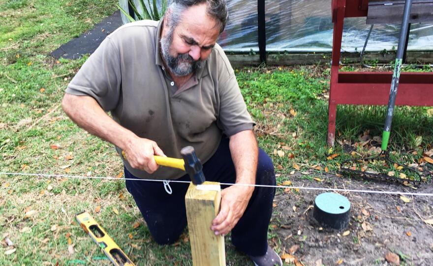  Marine Corps veteran Bernie Lodico straightens one of the fence posts in the Veterans Garden.