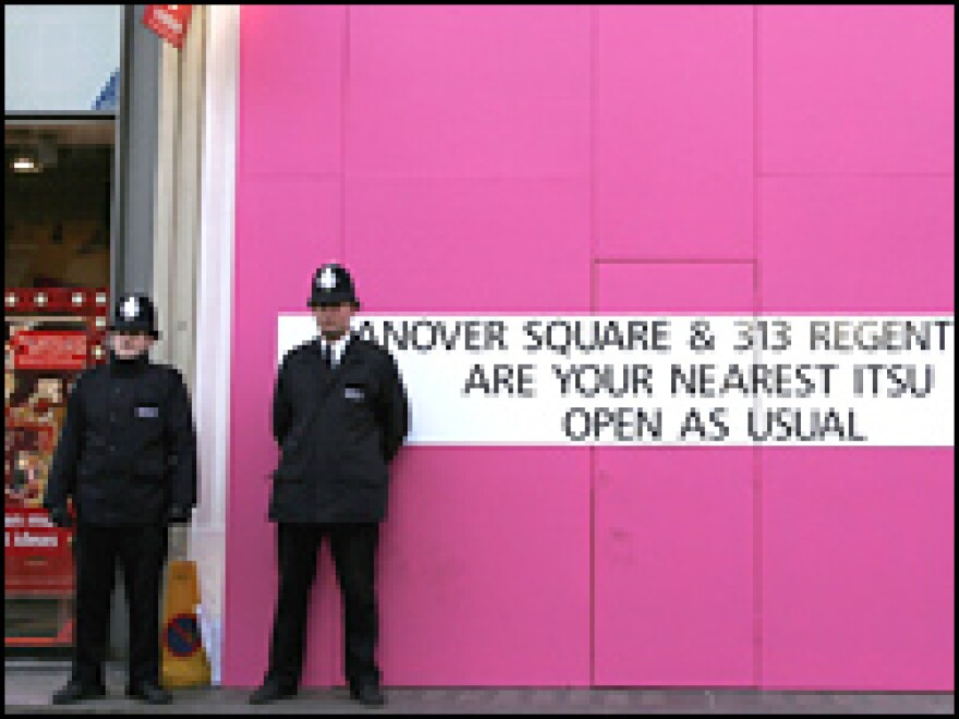 British police officers stand outside of a boarded-up Itsu restaurant in London. Detectives are continuing to examine five locations in London where traces of polonium-210 were found.