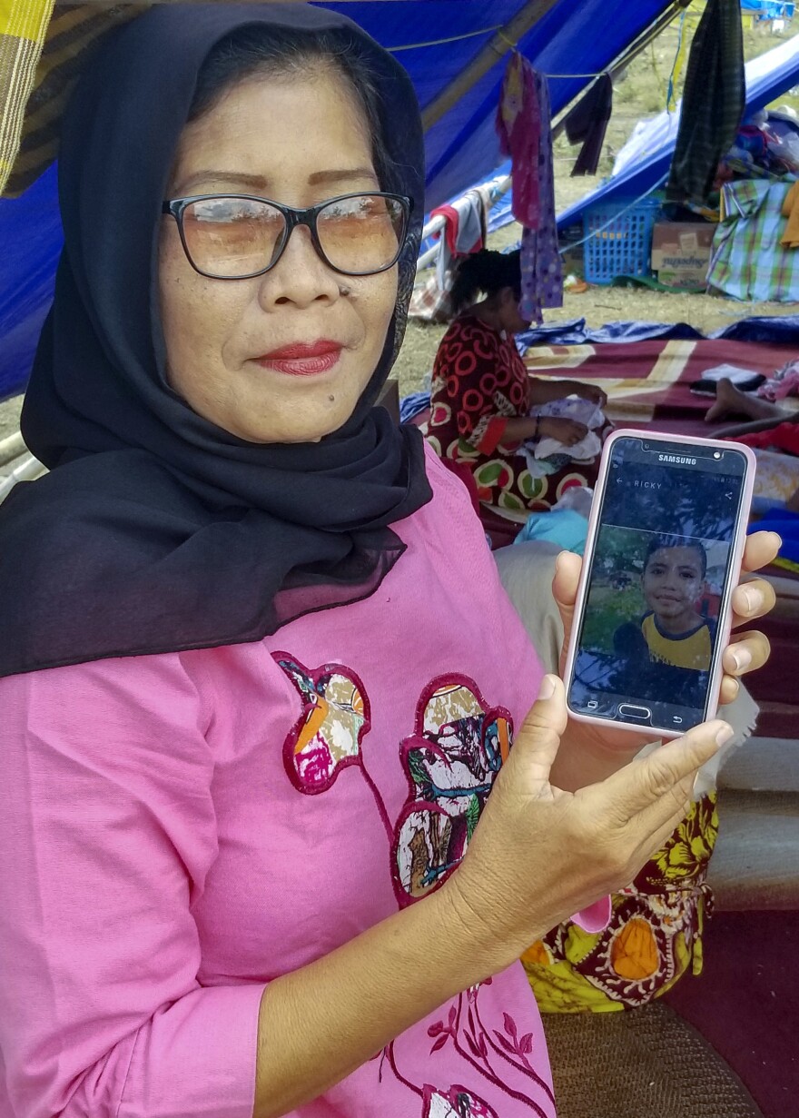 Evi Raharuddin, 54, shows a photo of her 9-year-old grandson, Raldi, who disappeared when the family ran from their house in the earthquake on September 28.