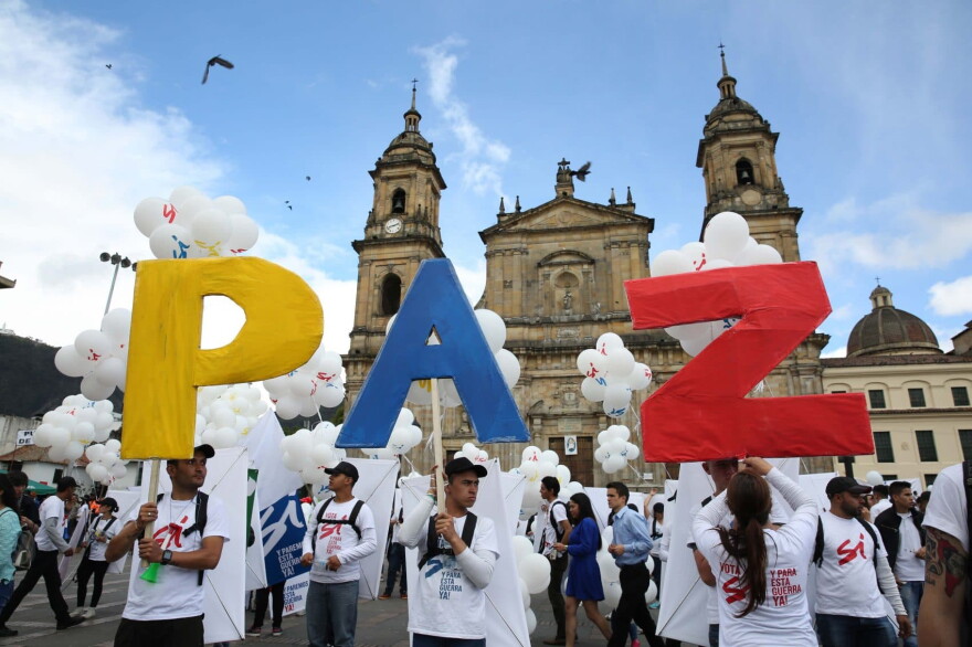 People hold up letters that form the word "Peace" in Spanish during a gathering at Bolivar square in Bogota, Colombia, Monday, Sept. 26, 2016. (Jennifer Alarcon/AP)