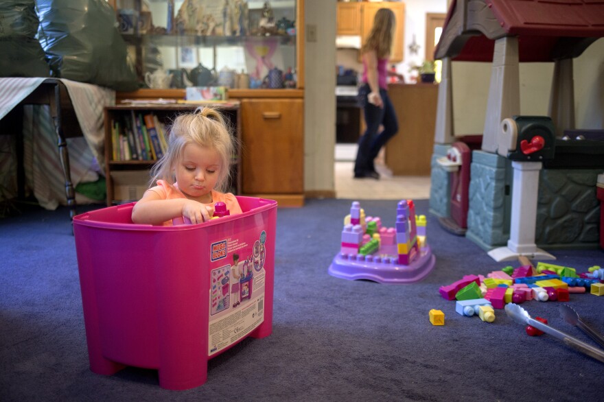 Audree, 2, plays while her mother, Samantha Watson, cleans the kitchen in 2016 in Maine. Watson, a single mother and nursing student, received benefits from the Temporary Assistance for Needy Families program.