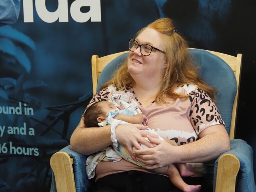 Amber Hood cradles her infant while speaking to Gov. Mike Braun during his tour of Shepherd Community Center’s Minnie Hartmann Neighborhood Childcare facility on Tuesday, July 21, 2026.