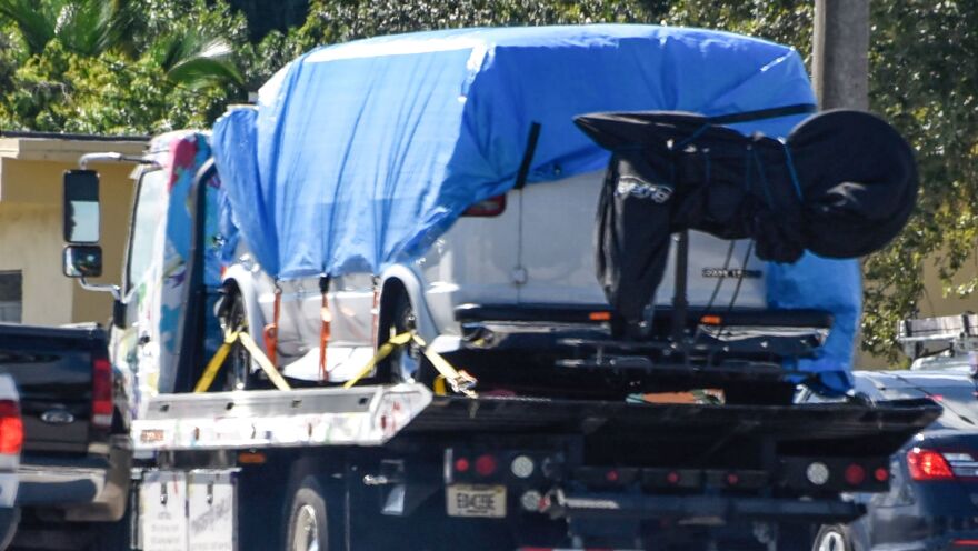 A van covered in blue tarp is towed by FBI investigators on Friday, in Plantation, Fla., in connection with the pipe bombs mailed to top Democrats.