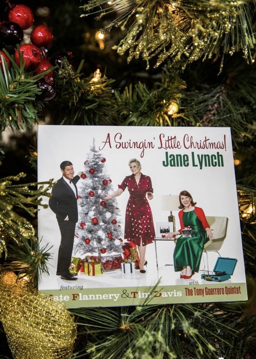 A man and two women stand around a Christmas tree on a CD cover.