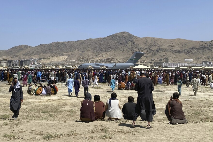 Hundreds of people gather near a U.S. Air Force C-17 transport plane at the perimeter of the international airport in Kabul, Afghanistan, on Aug. 16, 2021. SIGAR, released its interim report Wednesday detailing why Afghanistan's government and military collapsed immediately after the U.S. withdrawal.