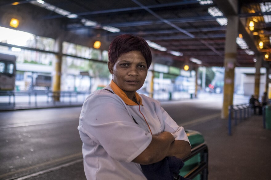 Anna Simpson, 41, who works in the kitchen of a Cape Town hospital, waits for a bus to take her home to the community called Lost City, where she lives with her husband. Many workers who keep crucial industries running live in townships and rely on public transport to get to work — putting them at risk of exposure to COVID-19.