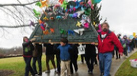 Mickey Inez, right, Thomas Madison, center, and Lisa Abbott carry the mountain's as they protest mountaintop removal Tuesday at the Capitol. The mountain, covered by pinwheels, was placed on the Governor's Mansion lawn.