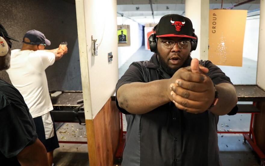 Paul Adell, a co-founder of the Rochester African American Firearms Association, demonstrates pistol grip technique at the at The Firing Pin gun range in Bergen. CREDIT MAX SCHULTE/WXXI NEWS