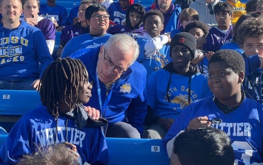 South Dakota State University president Barry Dunn chats with members of the Whittier Middle School 8th-grade football team during an SDSU football game