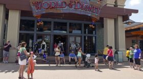 In this Friday, April 29, 2016 photo, visitors stroll by the World of Disney store at Disney Springs in Lake Buena Vista, Fla. ourism officials announced Monday, May 2, 2016, that the number of visitors coming to Orlando last year jumped 5.5 percent to more than 66 million visitors. That figure sets a record for tourists in Orlando and helps the central Florida city hang onto its bragging rights as the top tourist destination in the United States for the second year in a row. (AP Photo/John Raoux)