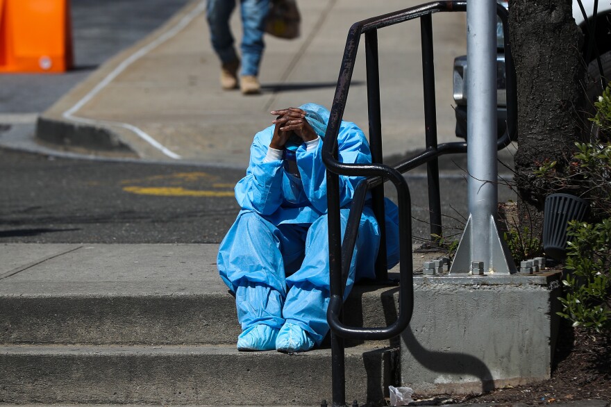 A fatigued health care worker takes a moment outside the Brooklyn Hospital Center in April. Many hospital workers these days have to cope with horrific tragedies playing out multiple times on a single, 12-hour shift. [Tayfun Coskun / Anadolu Agency via Getty Images]