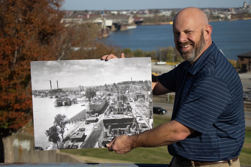 Carl holds the photo which contains elements such as docks from the WWII era shipyard that in part, still exists today.