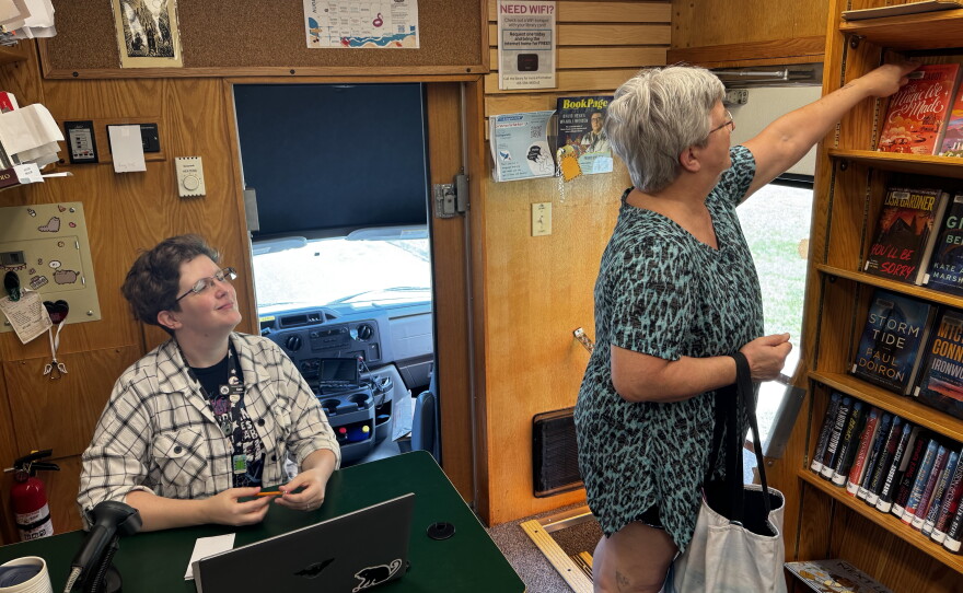 Chicopee librarian Kate Ouimette watches as resident Sarah Phaneuf looks for her next read on the Chicopee bookmobile.