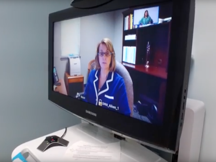 Sitting in her office, in Aiken, S.C., Dr. Ratliff conducts a telepsychiatry consultation to a patient sitting in a private room located at one of the emergency departments in S.C.