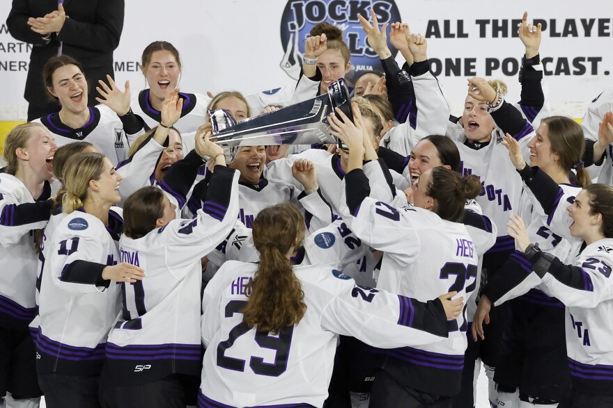 Minnesota players celebrate with the Walter Cup after defeating Boston to win the PWHL Walter Cup, May 29, 2024, in Lowell, Mass.