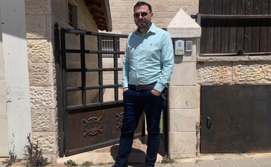 Yehuda Ben Sheetrit, an ultra-Orthodox Jewish Israeli, lost his wife, Osnat, to COVID-19. He stands outside the new apartment he has moved into with his four children after losing his wife.