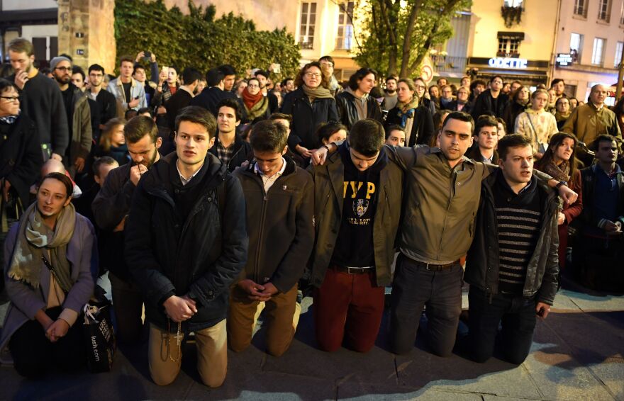 People kneeled in prayer as the flames engulf the Catholic Notre Dame Cathedral on Monday.