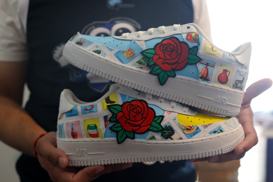 Jesse Acosta holds a pair of sneakers designed by one of the students in the Pasos for Oak Cliff educational program Aug. 18, 2025 in Dallas.