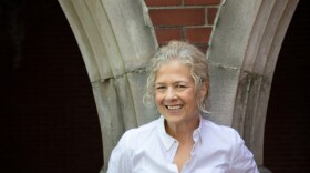 Lynell Edwards standing outside wearing a white blouse. Backdrop is brick architecture.