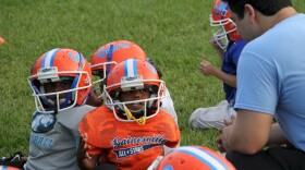 Assistant coach Austin Manning discusses the game with one of his players. The Mighty Mite team ranges from 5-7 years old.