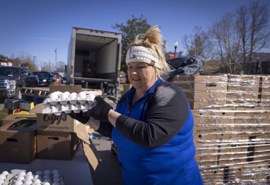 Lisa Barns stacks eggs during a food distribution event Nov. 18 in Dawson Springs.