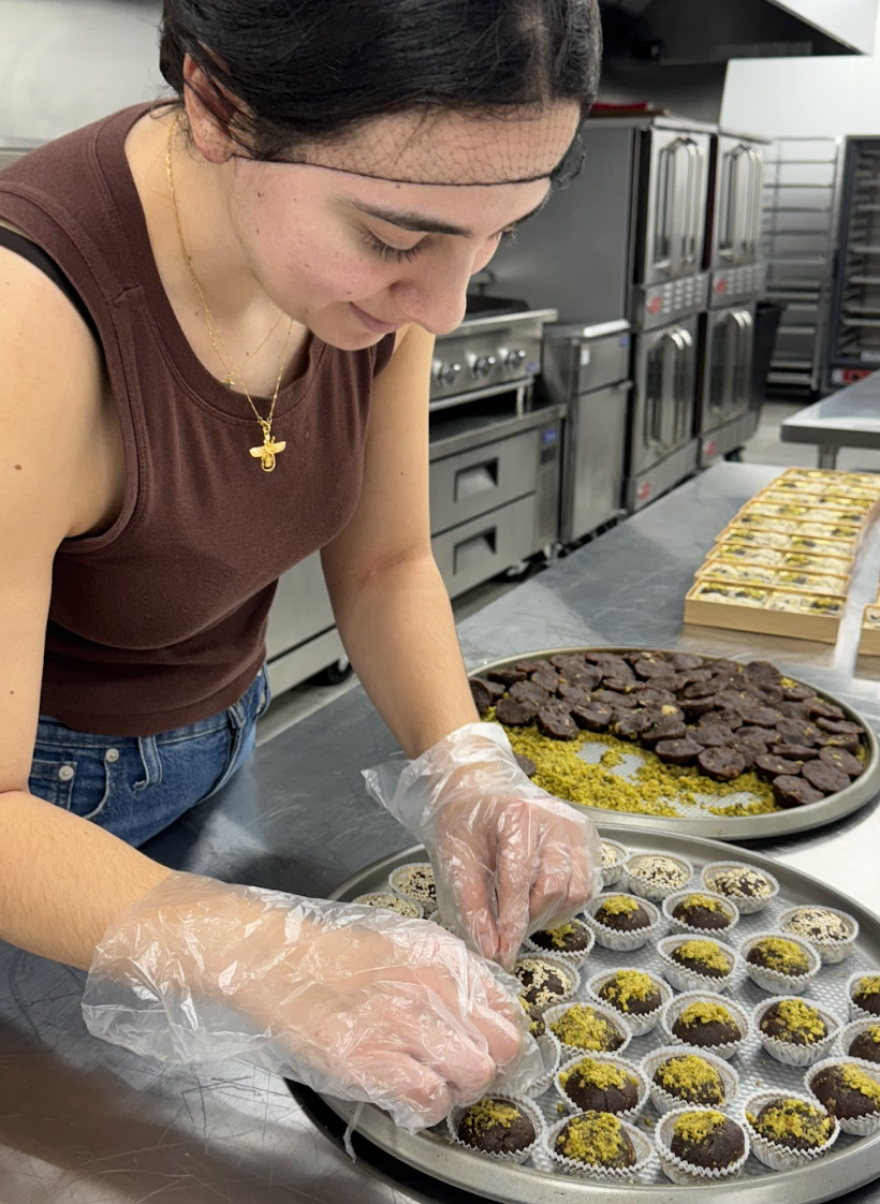 Armita Jamshidi en el trabajo, preparando bocadillos para los calambres en la cocina, combina pasión y propósito para revolucionar la atención sanitaria menstrual.