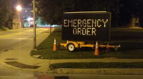 A flashing sign near Indiana University reminds residents that Bloomington is under an emergency order limiting private gatherings to 15 people.