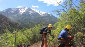 Meghan Patrick (izquierda) y Aryah Brown despejan la maleza y los matorrales sobrantes de una ladera en el valle del río Crystal con el monte Sopris al fondo.